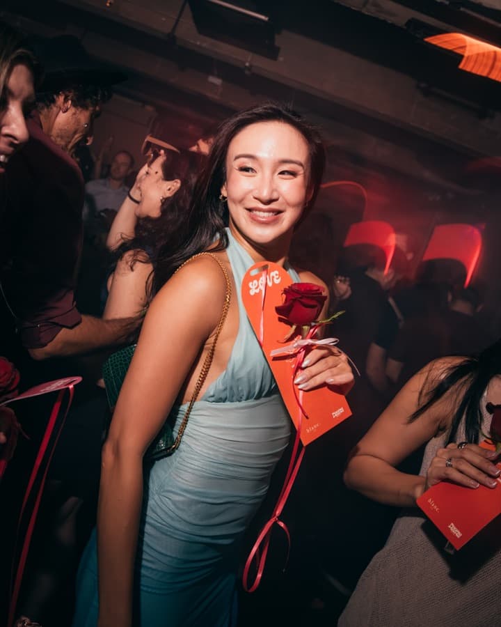 Guest holding a blanc. rose at a Valentine's party